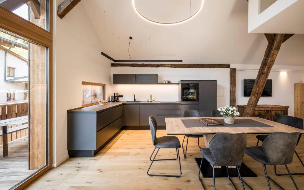 a kitchen and dining room with a table and chairs at Bachmannhof in Feldthurns