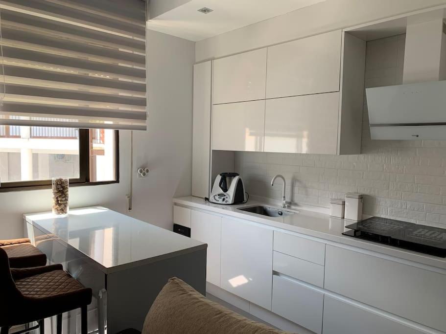 uma cozinha com armários brancos e uma bancada em Apto residencial piscina centro-Parking em Jaén