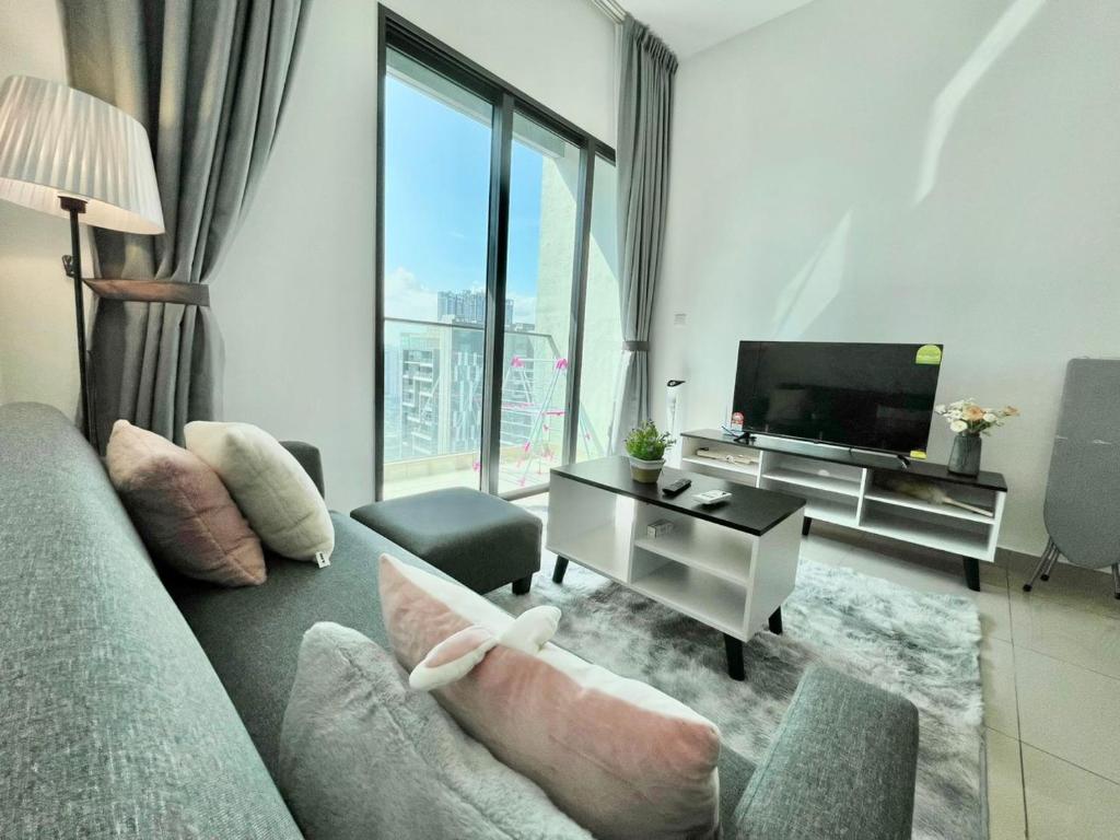 een woonkamer met een bank en een televisie bij 3 Room Cozy Comfy 1-11 pax Old Klang Road 7 min to Midvalley in Kuala Lumpur