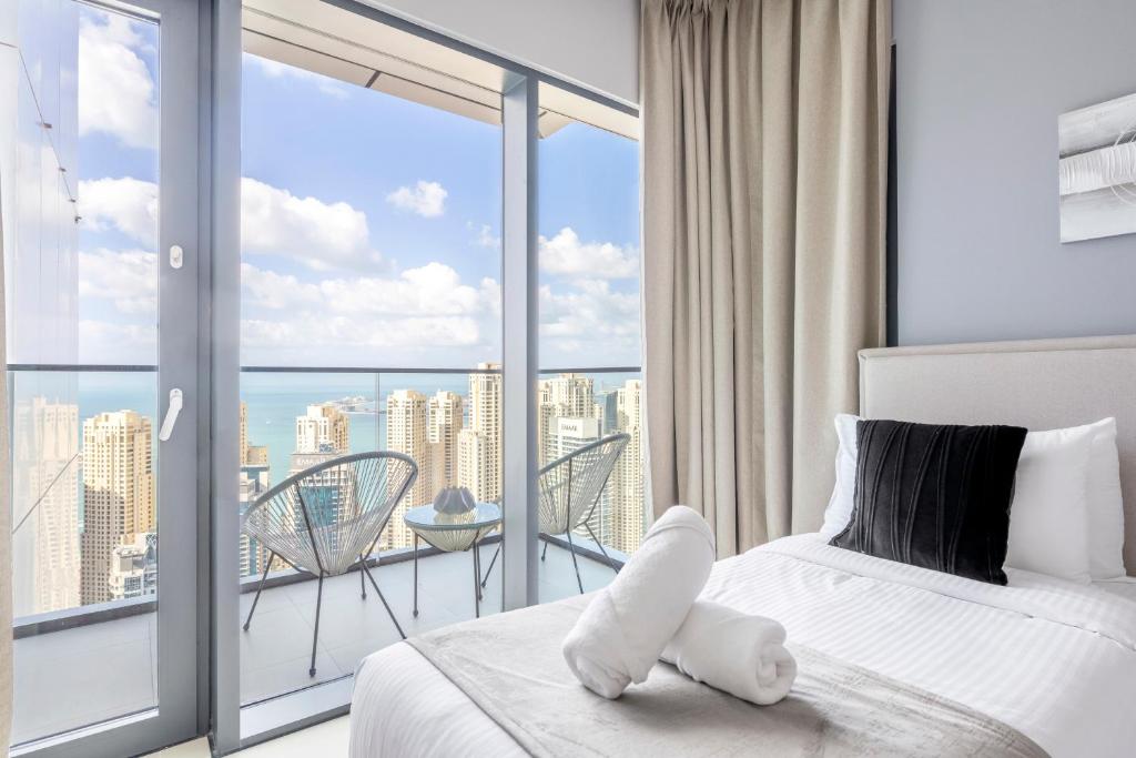a bedroom with a bed and a balcony with a view at Vida Dubai Marina & Yacht Club Residences in Dubai