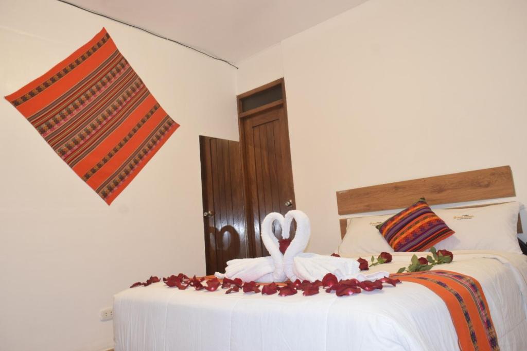 un dormitorio con una cama con una decoración de cisne en HOTEL VALLE DORADO MACHUPICCHU, en Machu Picchu