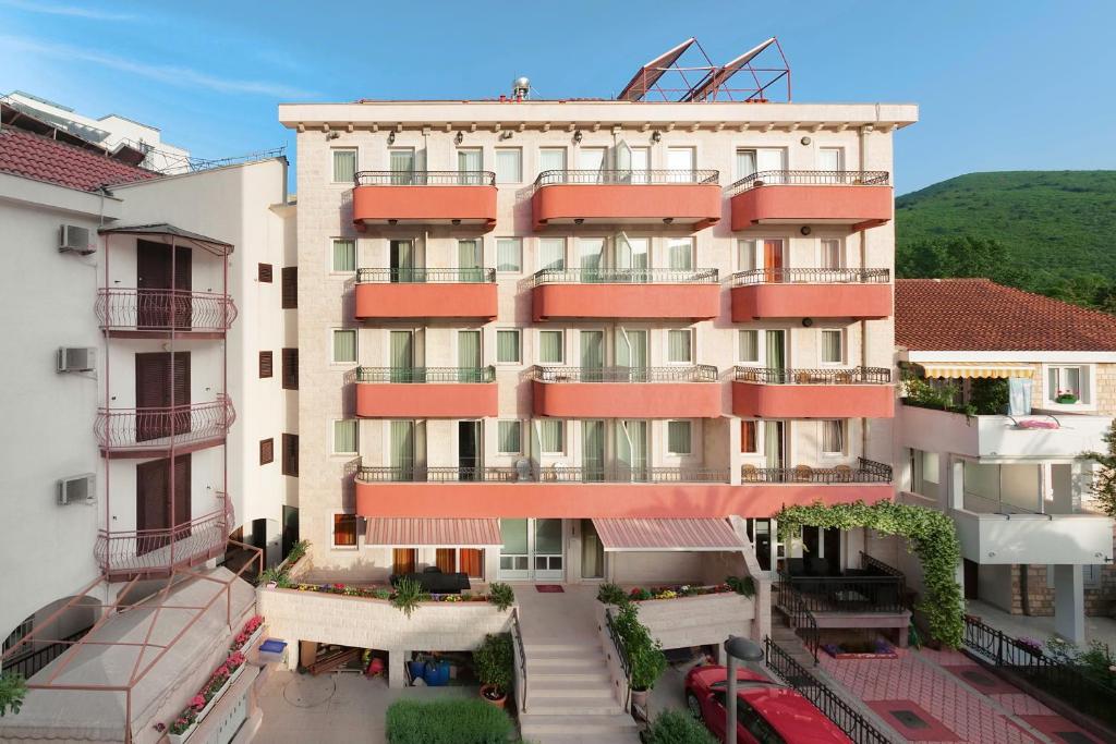 ein Apartmenthaus mit roten Balkonen in einer Stadt in der Unterkunft Apartments Ivona in Budva
