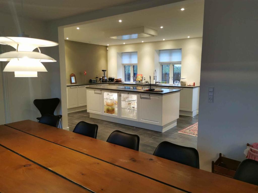 a dining room with a table and a kitchen at Lovely Farmhouse For The Whole Family in Slagelse
