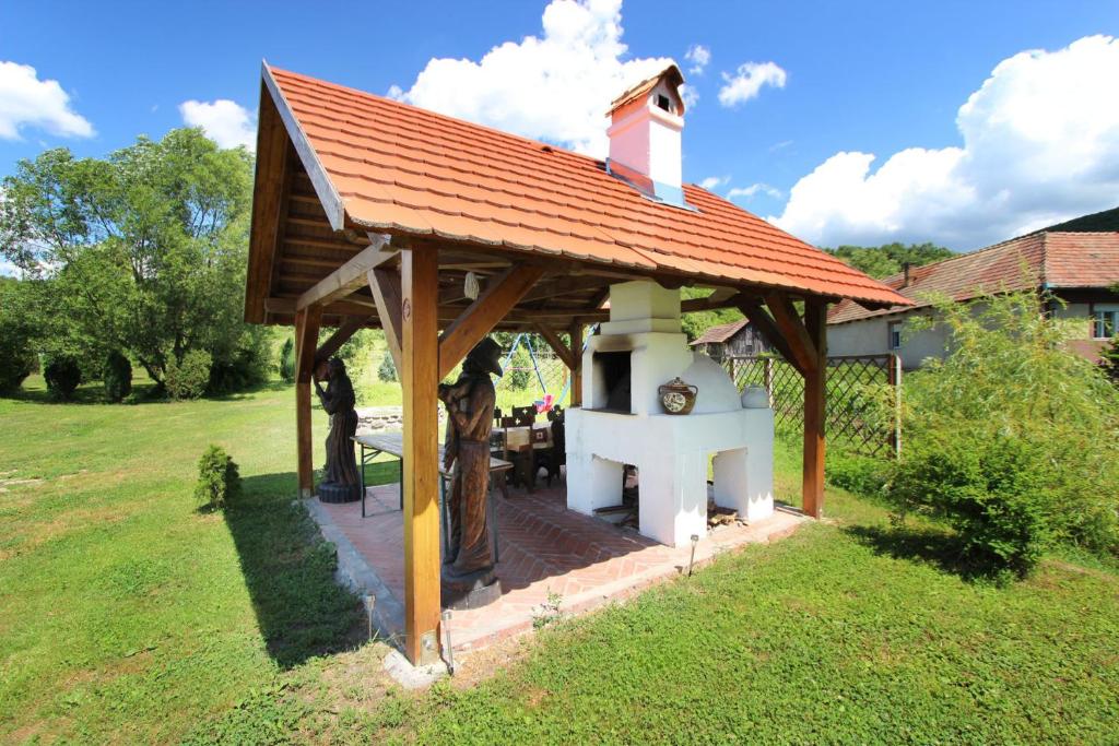 a small house with a roof on a yard at Toldi Vendégház in Felsőtold