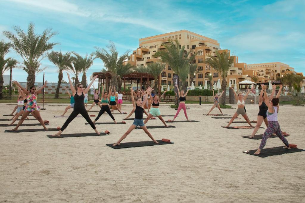 a group of people doing yoga on the beach at Rixos Bab Al Bahr - Ultra All Inclusive in Ras al Khaimah