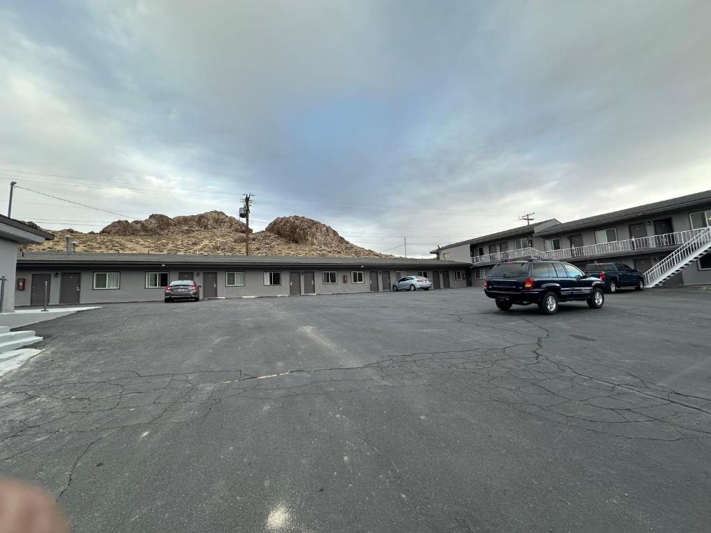 a parking lot with a car parked in front of a building at Dream Inn in Tonopah