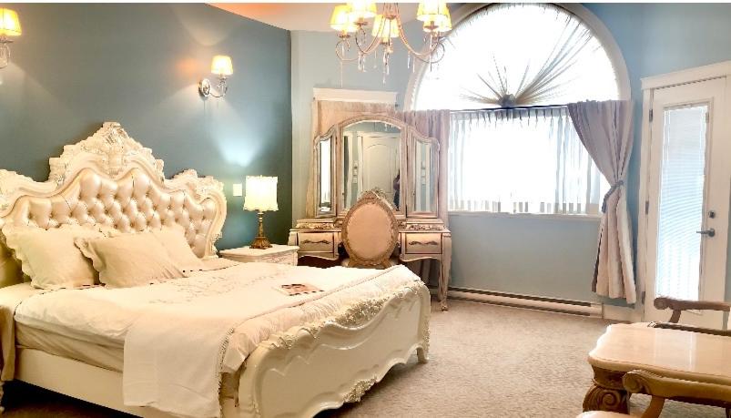a bedroom with a large white bed and a mirror at Angel 3 in Victoria