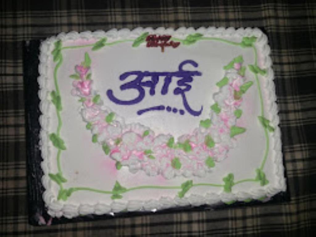 un pastel de cumpleaños con flores en una mesa en Heritage Resort , Kolhapur, en Kolhapur