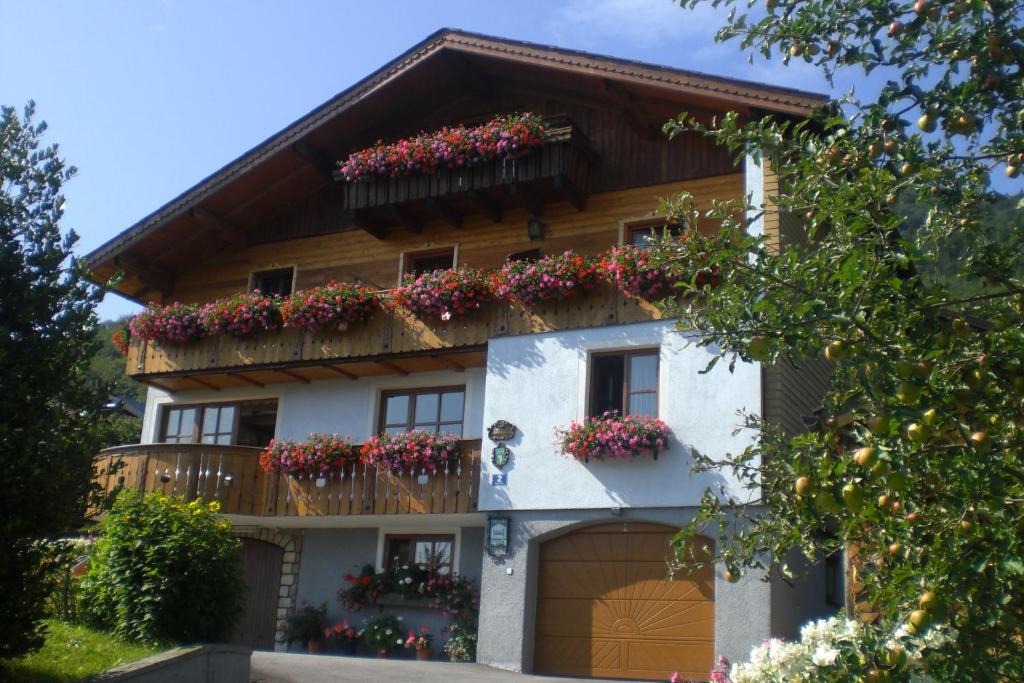 una casa con flores en el balcón en Haus Klaushofer, en Fuschl am See