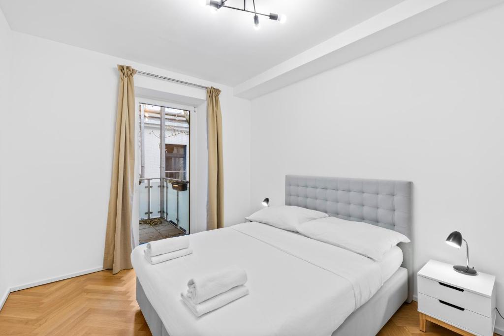 a white bedroom with a large bed and a window at Vienna Chic Residences #King Suite #Brand New# in Vienna