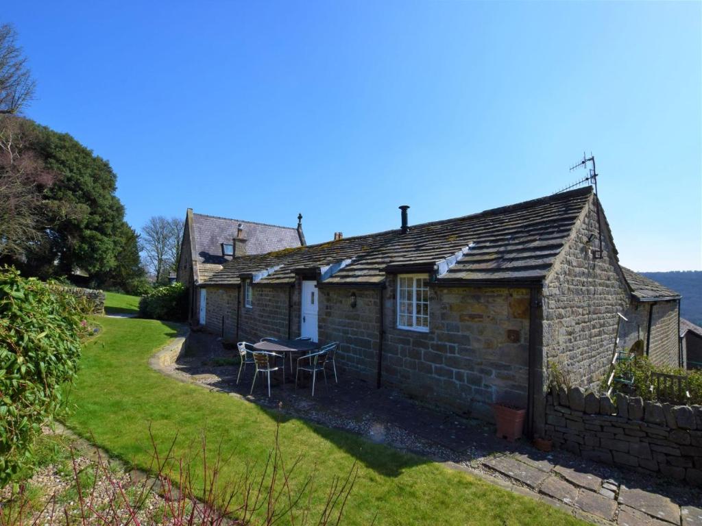 an old stone cottage with a table in the yard at 3 Bed in Sheffield 81249 in Sheffield