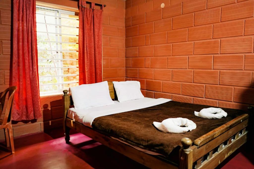 2 Handtücher auf einem Bett in einem Zimmer mit Fenster in der Unterkunft Eshwari Cottage in Madikeri