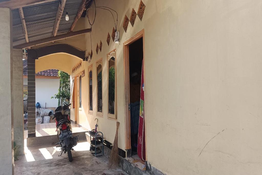 a motorcycle is parked outside of a building at OYO 93435 Yuda Family Homestay in Lembuak