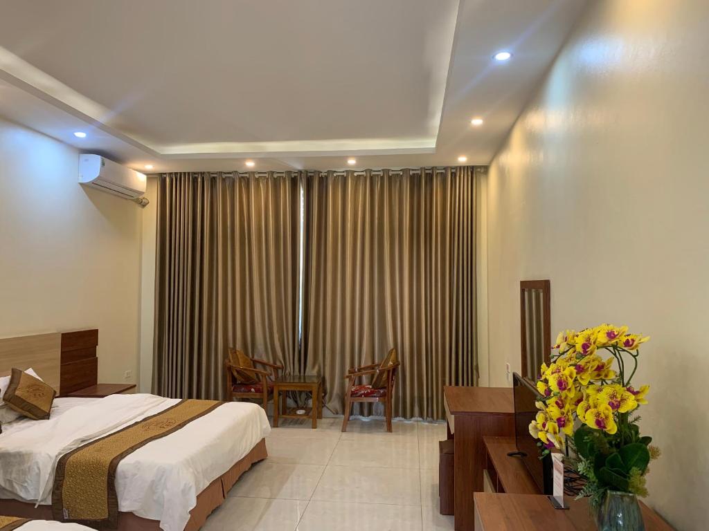 una habitación de hotel con una cama y una mesa con flores en ĐÔNG THÀNH, en Hòa Ðình