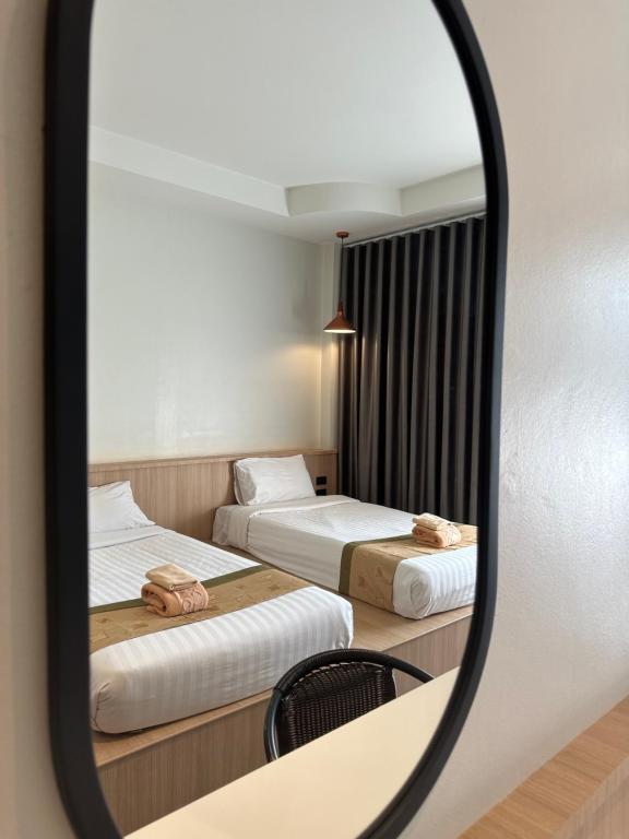 espejo que refleje 2 camas en una habitación de hotel en Diamond Park Inn Chiangrai & Resort, en Chiang Rai
