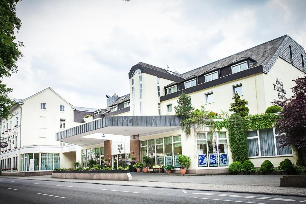 een groot wit gebouw met veel ramen bij Hotel Deutscher Hof in Trier