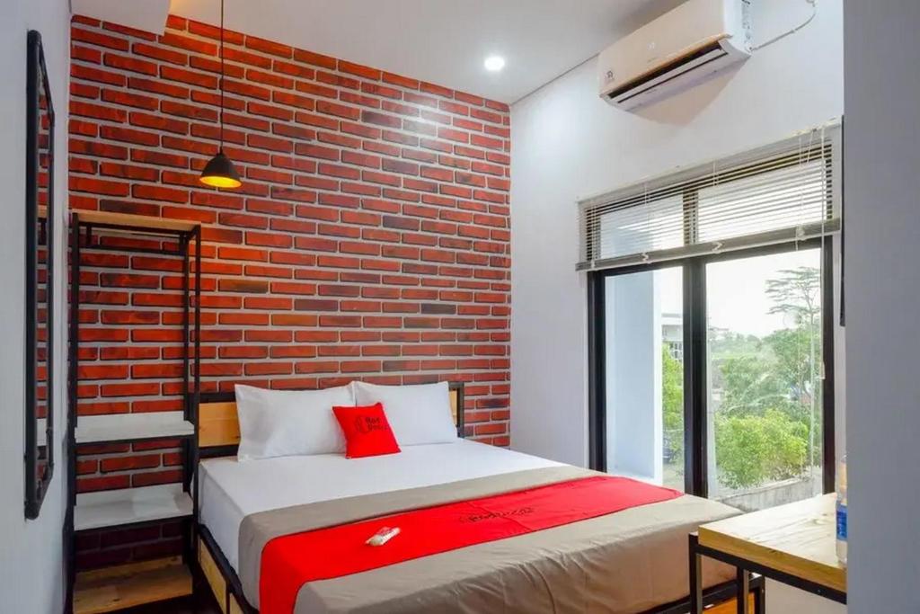 uma cama num quarto com uma parede de tijolos em RedDoorz near Universitas Muhammadiyah Purwokerto 2 em Kembaran
