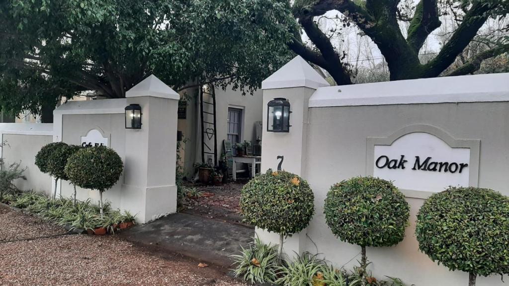 a white wall with a out manor sign on it at Cafe Felix & Old Oak Manor in Riebeek-Kasteel