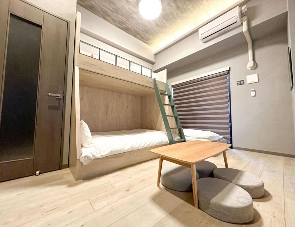 a room with a bed and a table and a chair at Rakuten STAY Fukuoka Yakuin Bunk bed Triple Room in Fukuoka