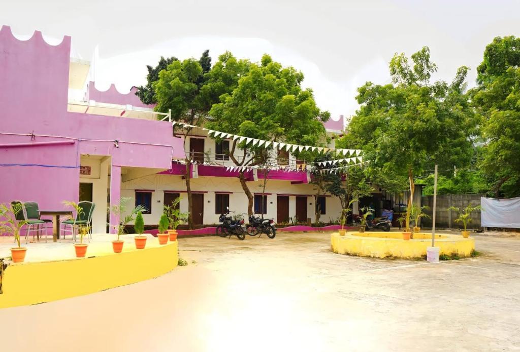 a group of buildings with trees and motorcycles in front at Paradise Feel Dreamy Resort in Puducherry