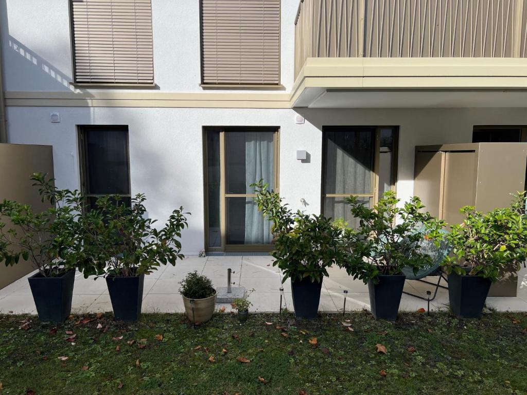 uma fila de vasos de árvores em frente a uma casa em Ferienwohnung Isenberg em Bad Reichenhall