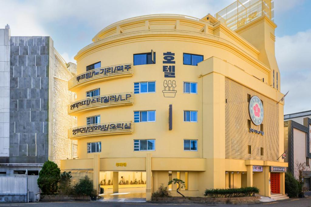 um grande edifício amarelo com um relógio em Jeonju AANK Hotel em Jeonju