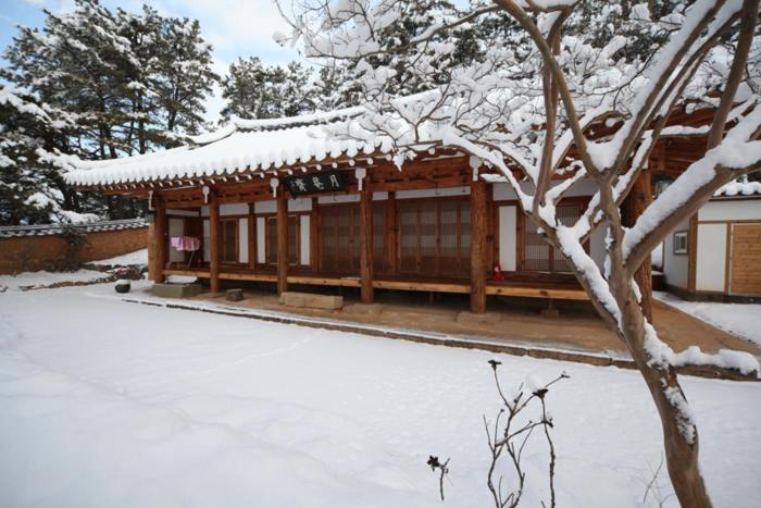 a building with a snow covered roof in a yard at Wolamjae in Gyeongju