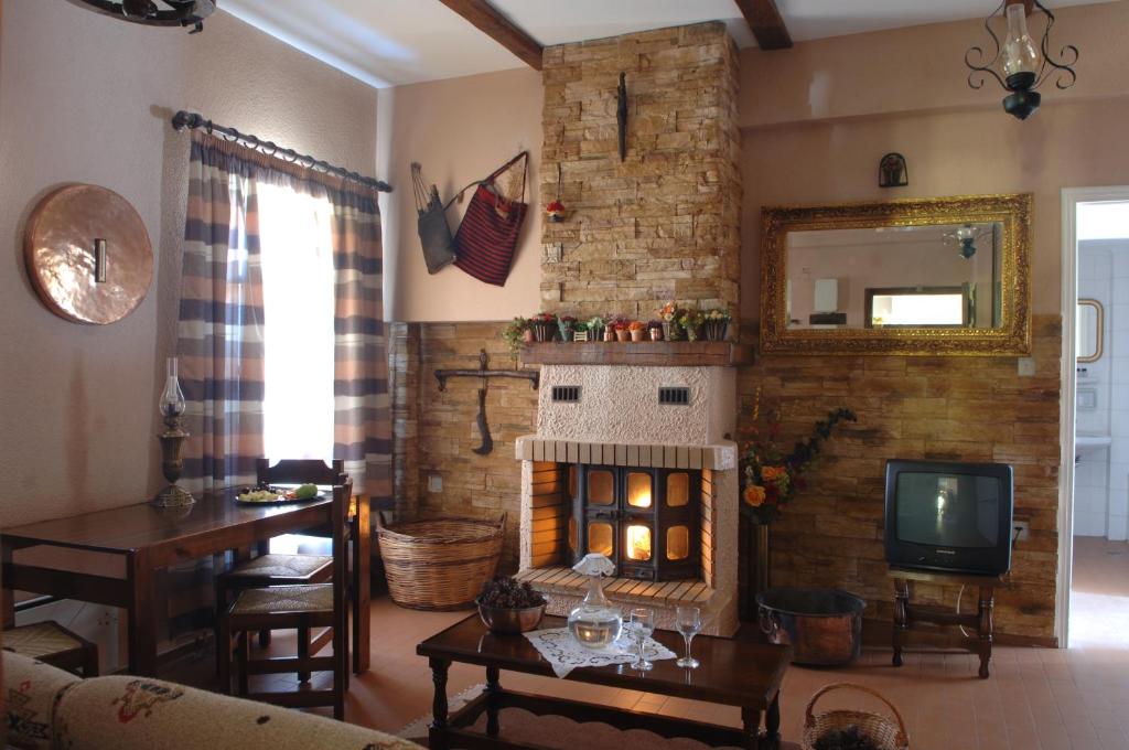 a living room with a fireplace and a television at Villa Filoxenia Arahova in Arachova