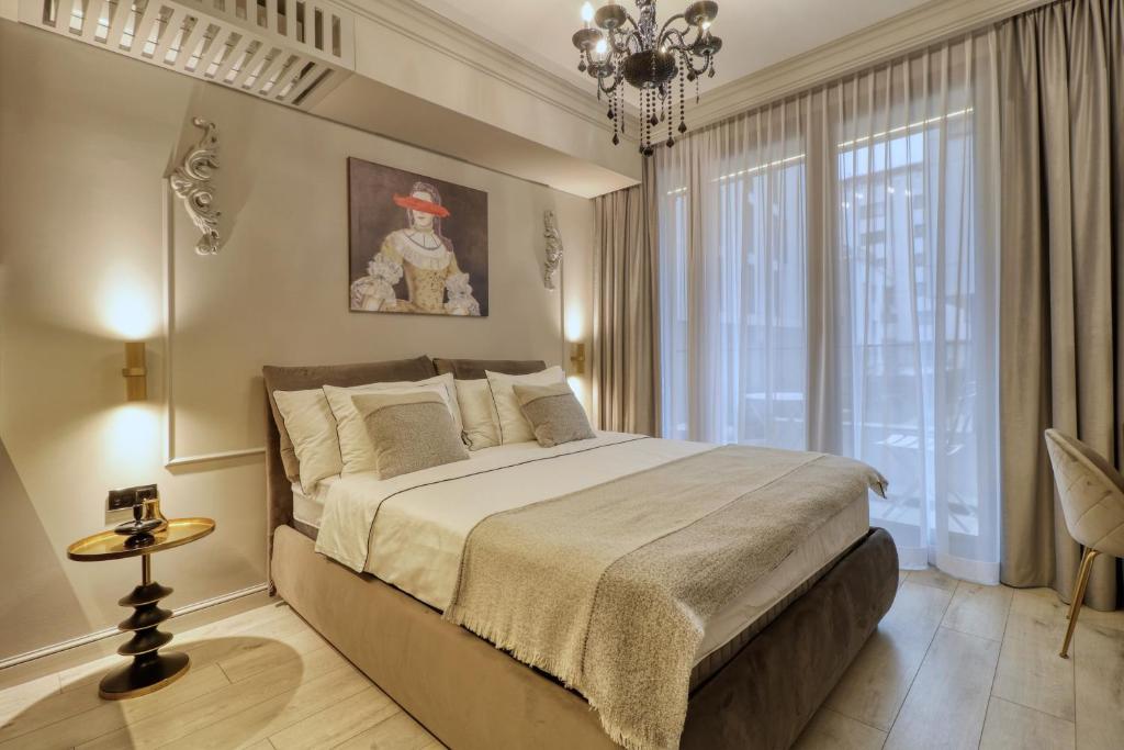 um quarto com uma cama grande e um lustre em Herastrau Luxury Studios em Bucareste
