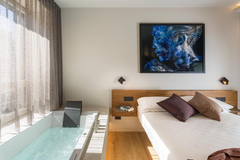 een slaapkamer met een bed en een schilderij aan de muur bij Aera Luxury Suites - 301 302 in Catania