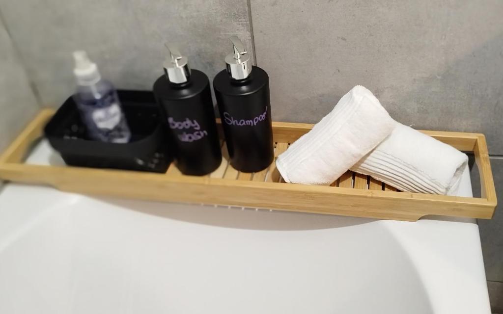a wooden shelf with three bottles and towels at Take your time in Cluses