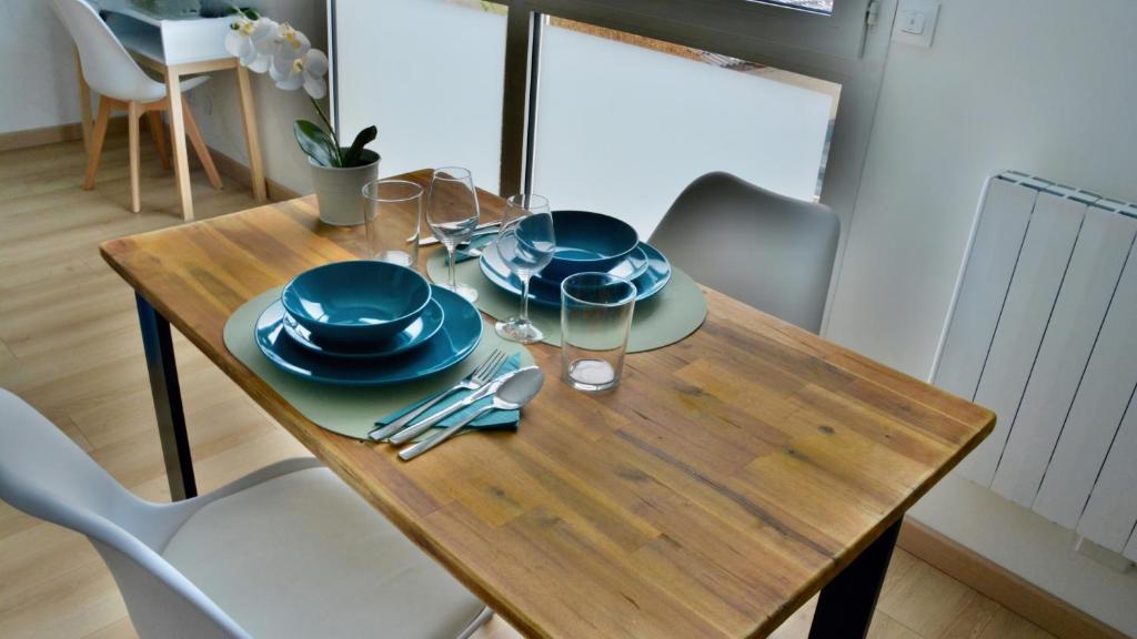 a wooden table with blue plates and silverware on it at Take your time in Cluses