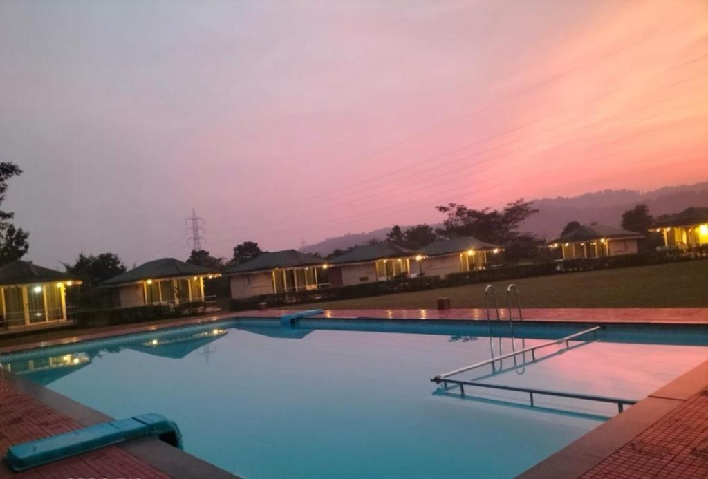科波利的住宿－Nature Trails Durshet, Khopoli，一座享有日落美景的大型游泳池