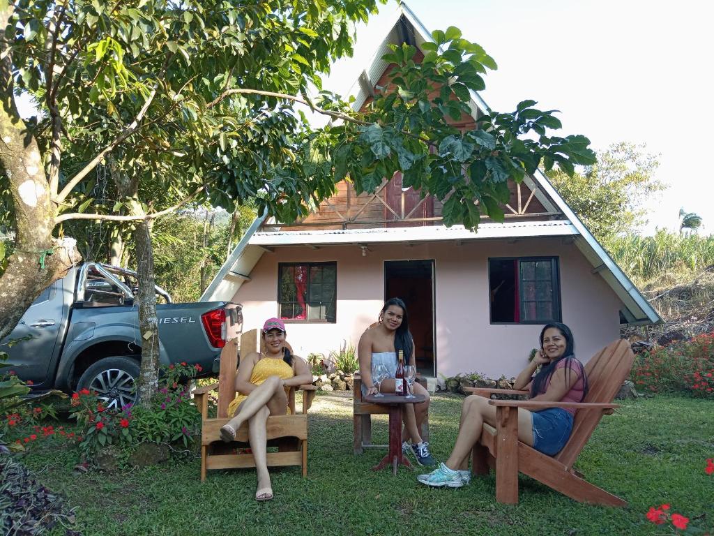 El Quije的住宿－Hostal claire，三名妇女坐在房子前面的椅子上