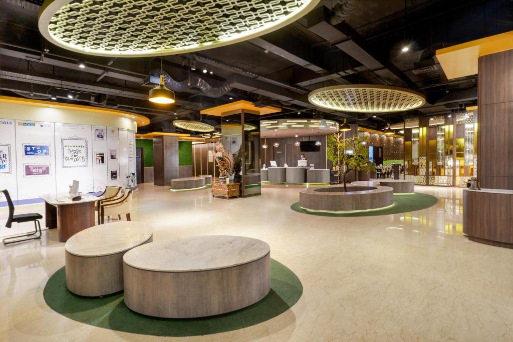 a large room with tables and chairs in a building at Golden Tulip Springhill Lampung in Bandar Lampung