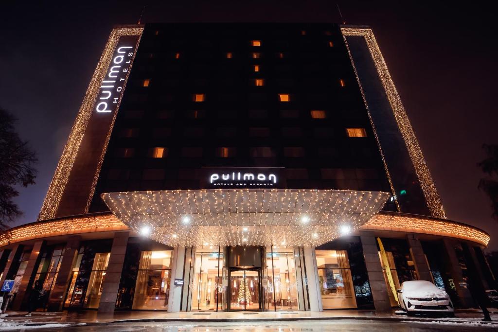 un edificio con un cartel que lee puma por la noche en Pullman Bucharest World Trade Center, en Bucarest