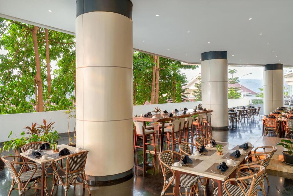 a restaurant with tables and chairs with birds on them at Golden Tulip Springhill Lampung in Bandar Lampung