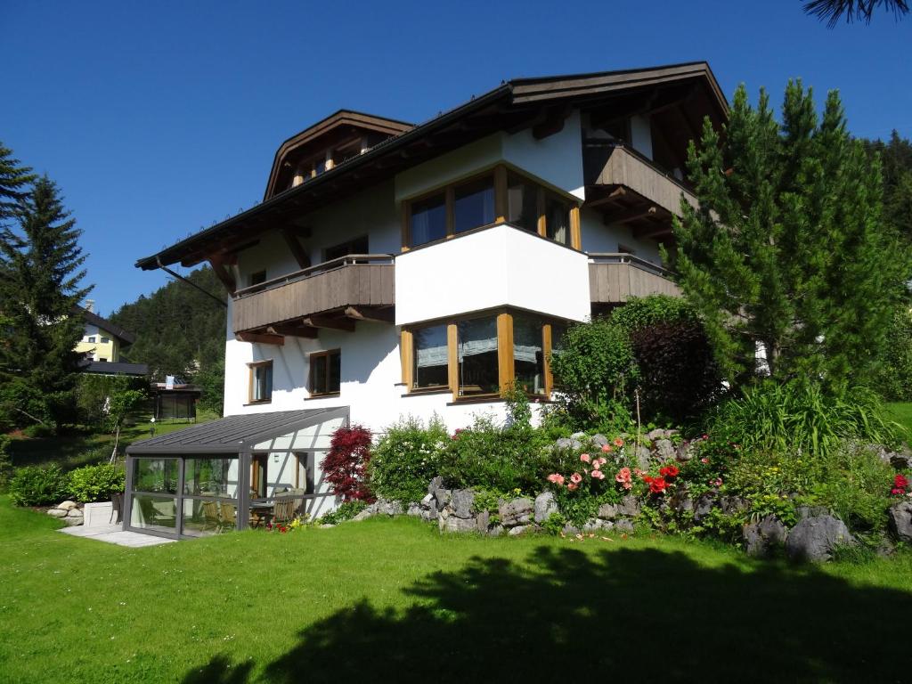duży biały dom z ogrodem przed nim w obiekcie Appartementhaus St. Martin w mieście Seefeld in Tirol