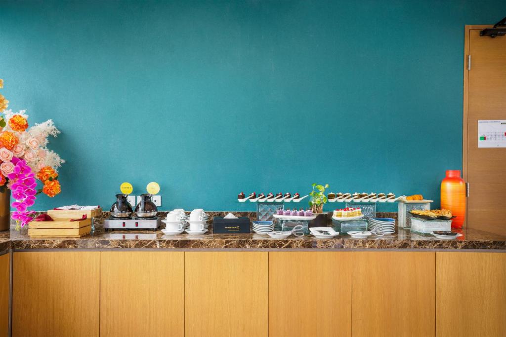 a buffet with cakes and other desserts on a counter at Golden Tulip Springhill Lampung in Bandar Lampung