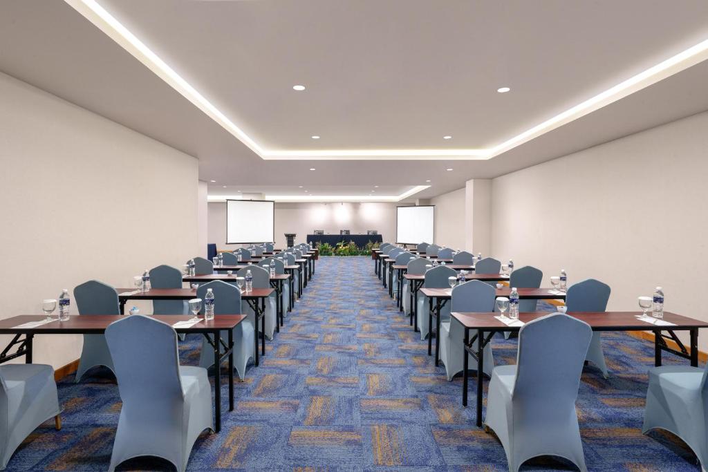 a large room with tables and chairs in it at Golden Tulip Springhill Lampung in Bandar Lampung