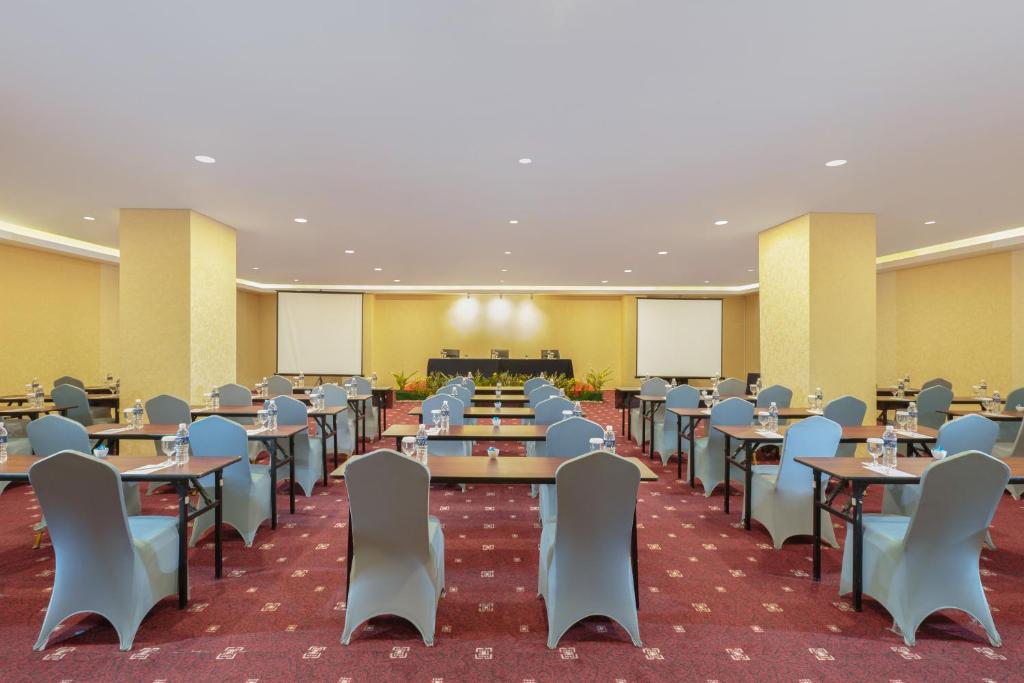 an empty banquet hall with tables and chairs at Golden Tulip Springhill Lampung in Bandar Lampung