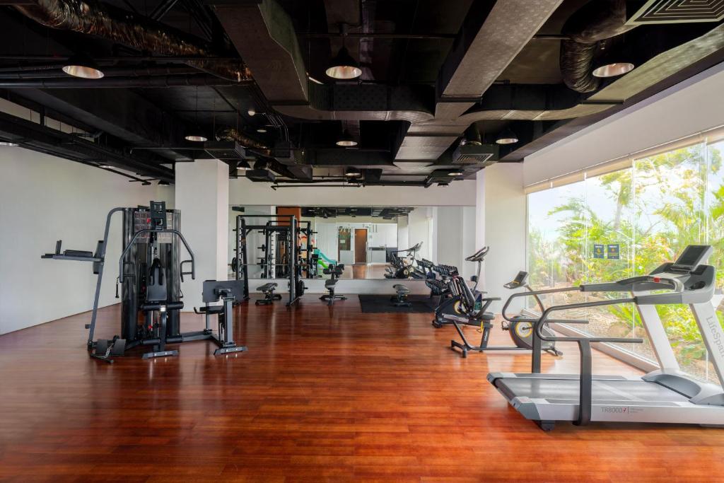 a gym with treadmills and elliptical machines at Golden Tulip Springhill Lampung in Bandar Lampung