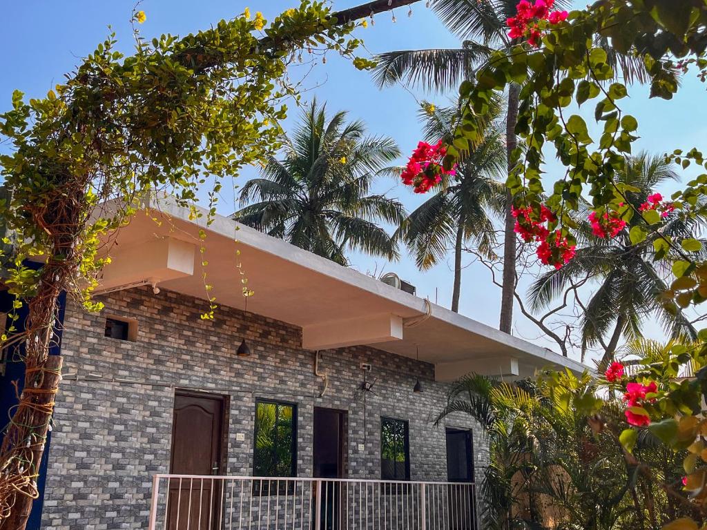 a house with palm trees in front of it at Arzu Homes in Anjuna