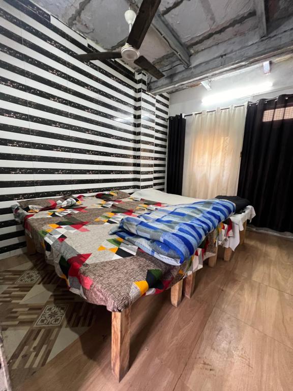 a bedroom with a bed with a quilt on it at Shyam Sadan Guest House in Vrindāvan