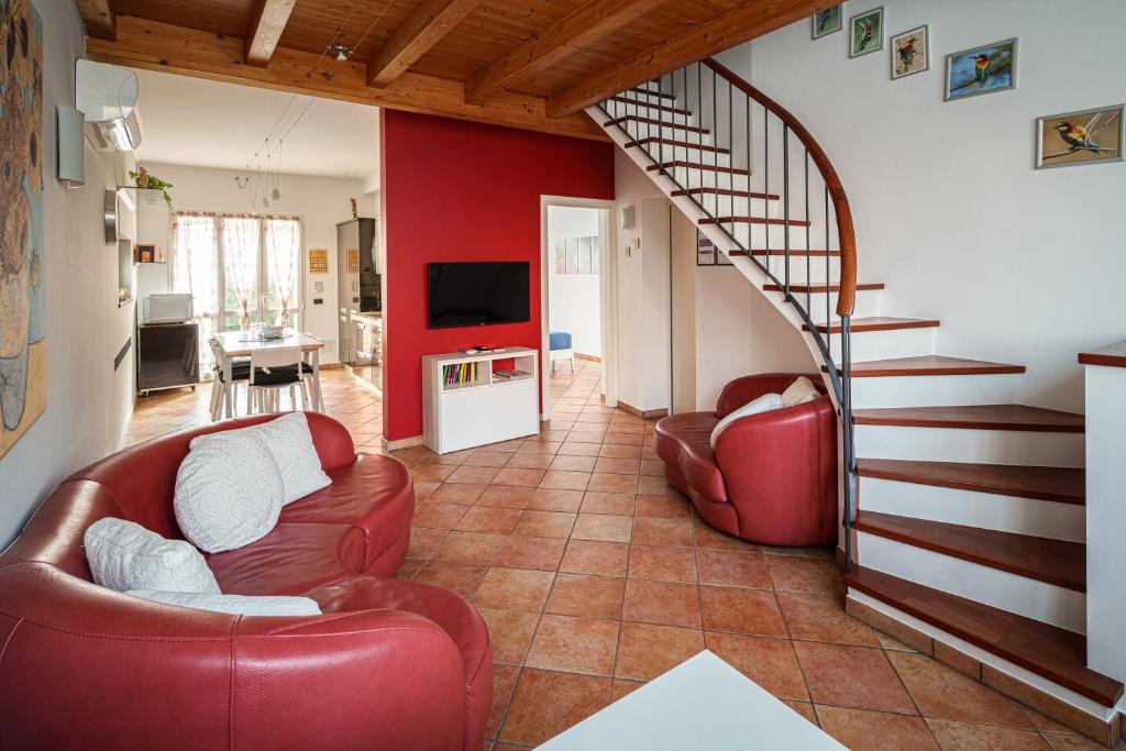 米蘭的住宿－Accomodo MIT39 Trivano San Siro，客厅设有2把红色椅子和楼梯