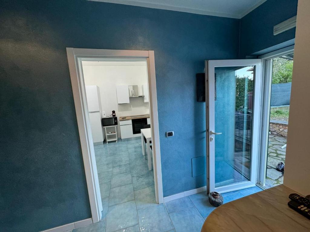 a room with a blue wall with a door and a kitchen at CASA MEDUSA in La Spezia