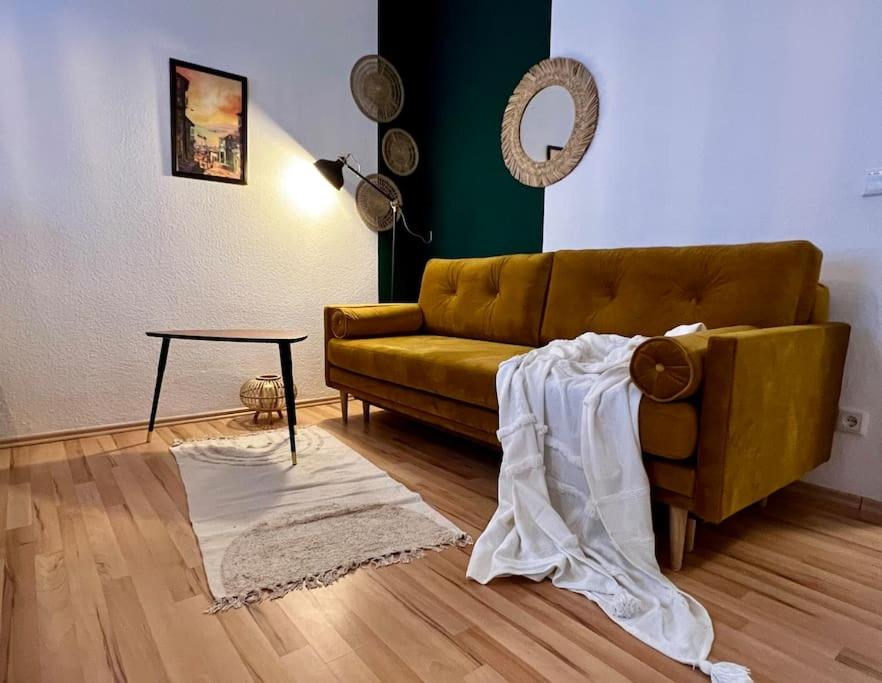sala de estar con sofá marrón y mesa en Ruhig & Zentral - 2 Kingsize Betten - Wi-Fi, en Essen