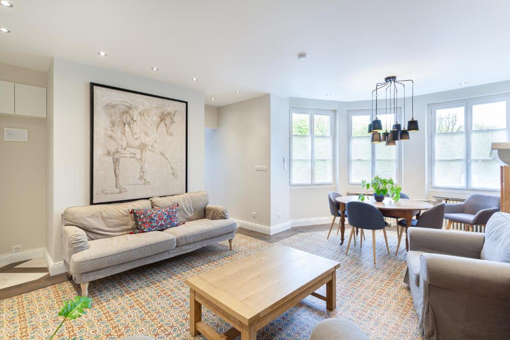 a living room with a couch and a table at Les appartements de Chantilly - gare in Chantilly