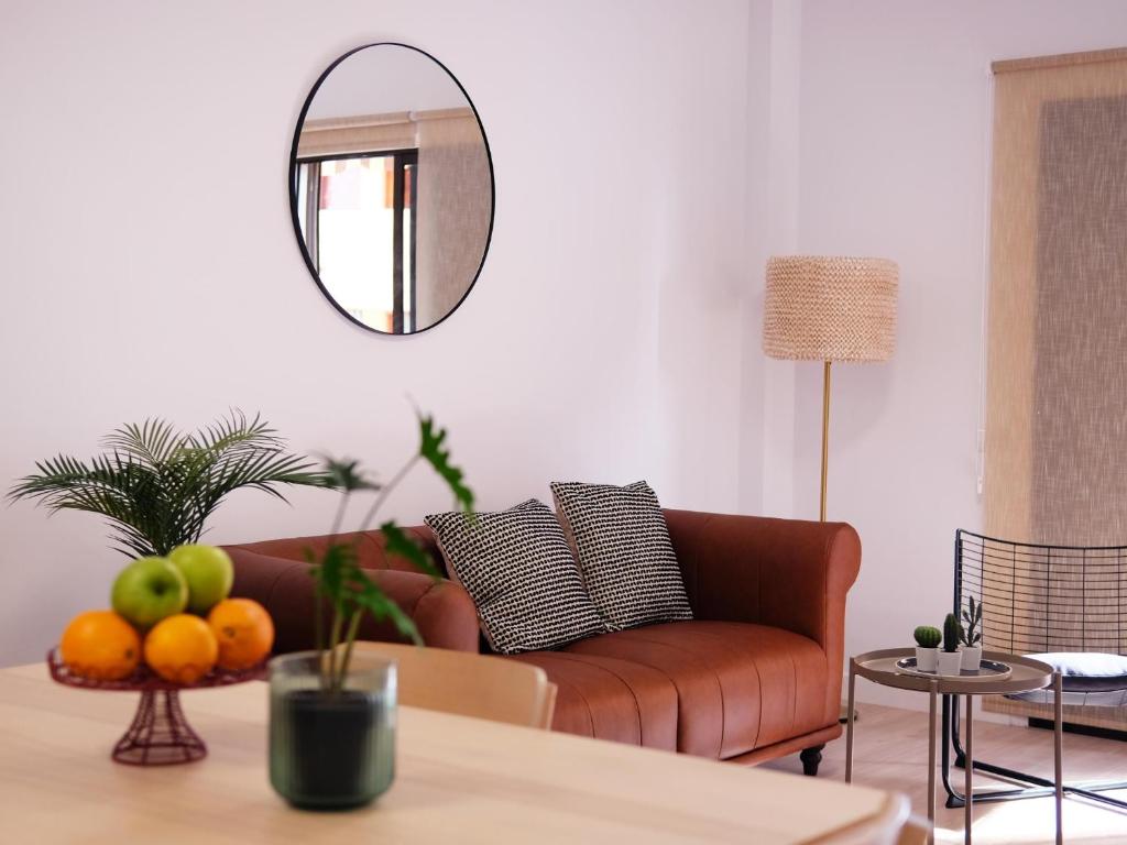 sala de estar con sofá y espejo en Elegant apartment with private workspace, en Candelaria