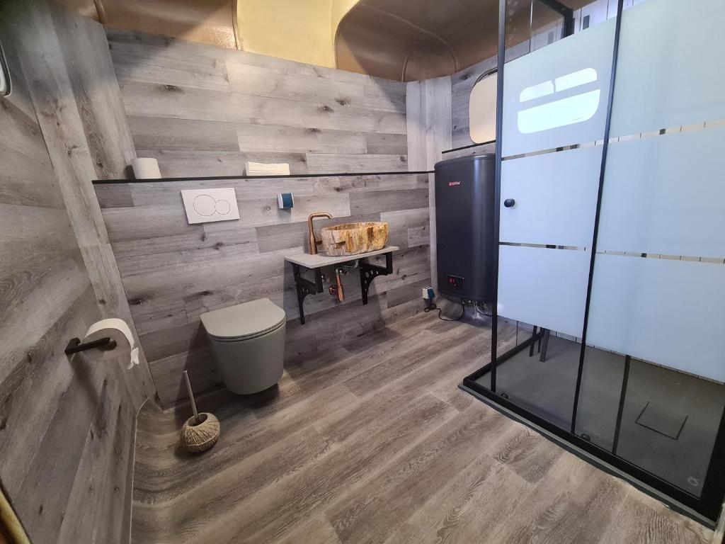 a bathroom with a toilet and a wooden wall at Honeymoon Zelt im Ruhrpott in Oberhausen